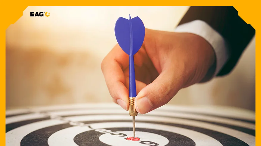 pessoa inserindo um dardo da cor azul em um alvo, ilustrando a definição de público-alvo