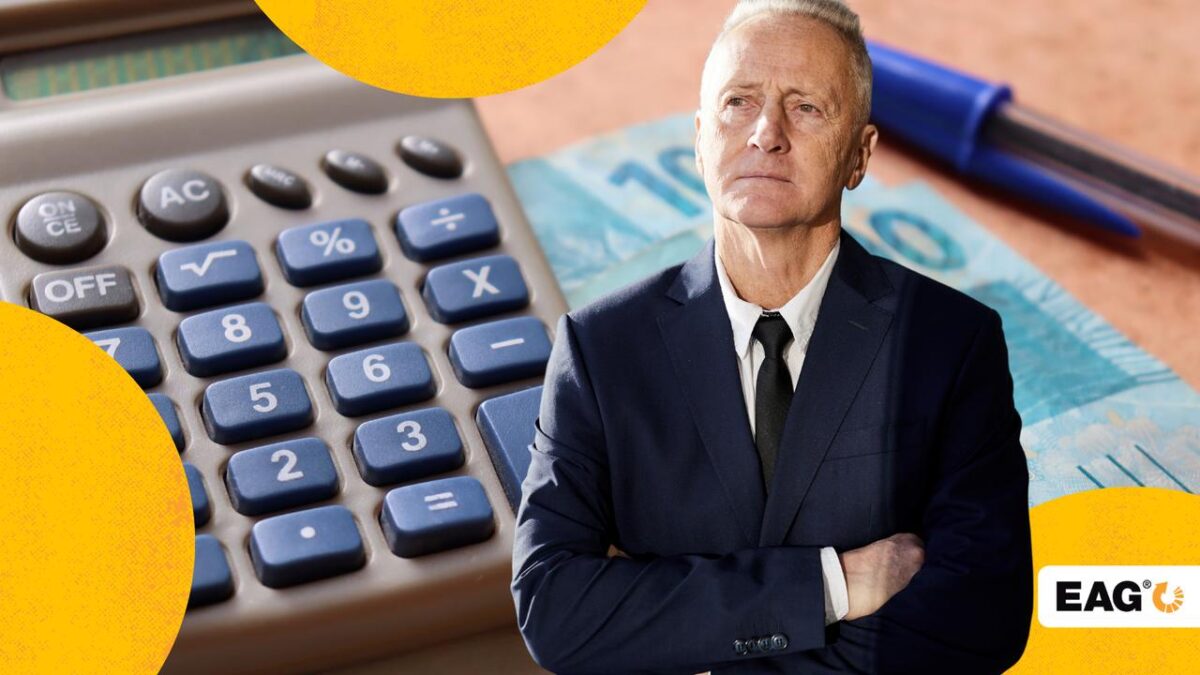 Empresário de braços cruzados. Atrás, uma calculadora e dinheiro do salário do empresário