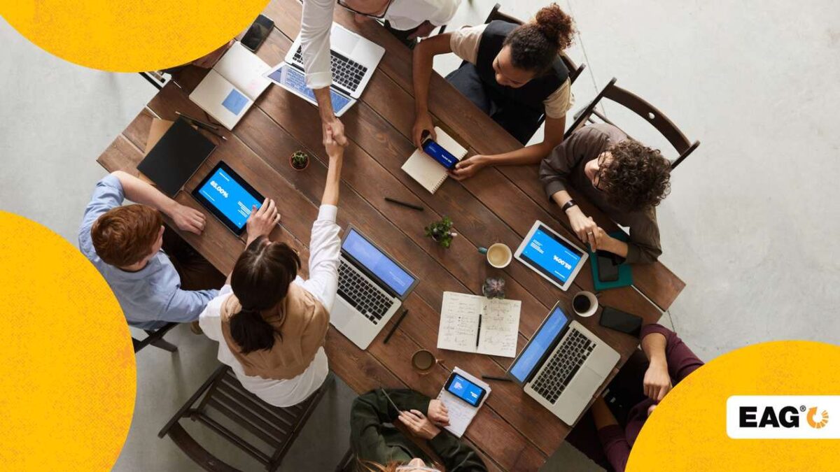 reunião com sete líderes diferentes sentados em uma mesa e conversando sobre os próximos passos da empresa||||