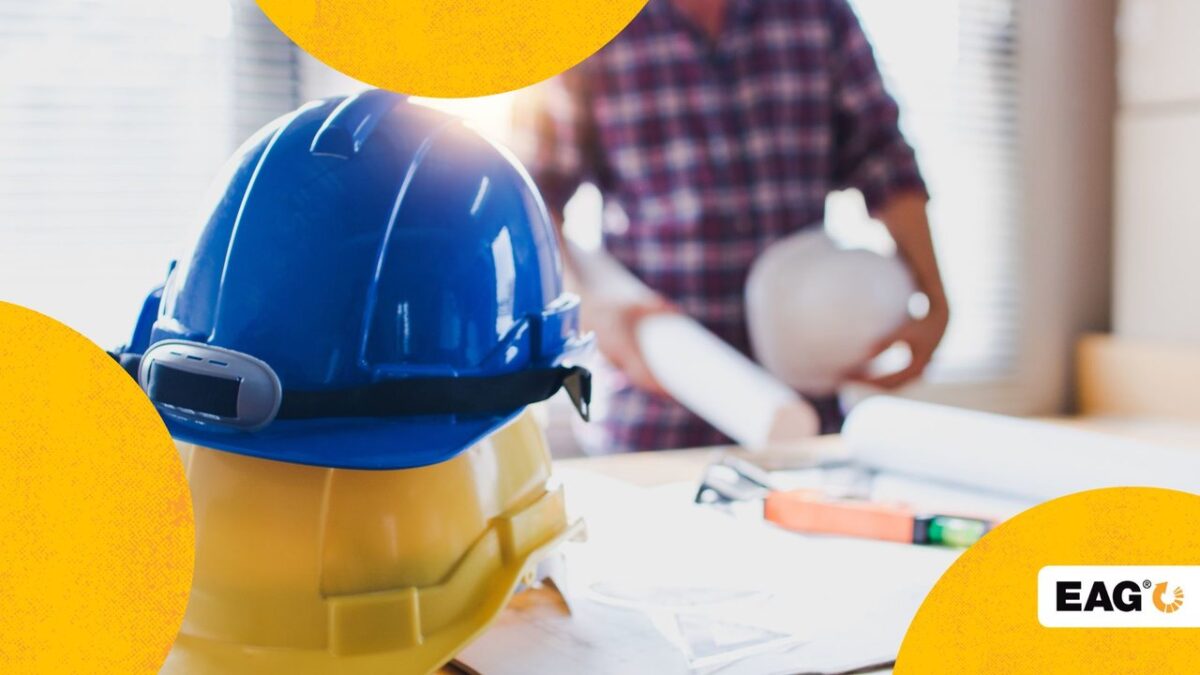 pessoa ao fundo e na frente dois capacetes de proteção da cor azul e amarela||